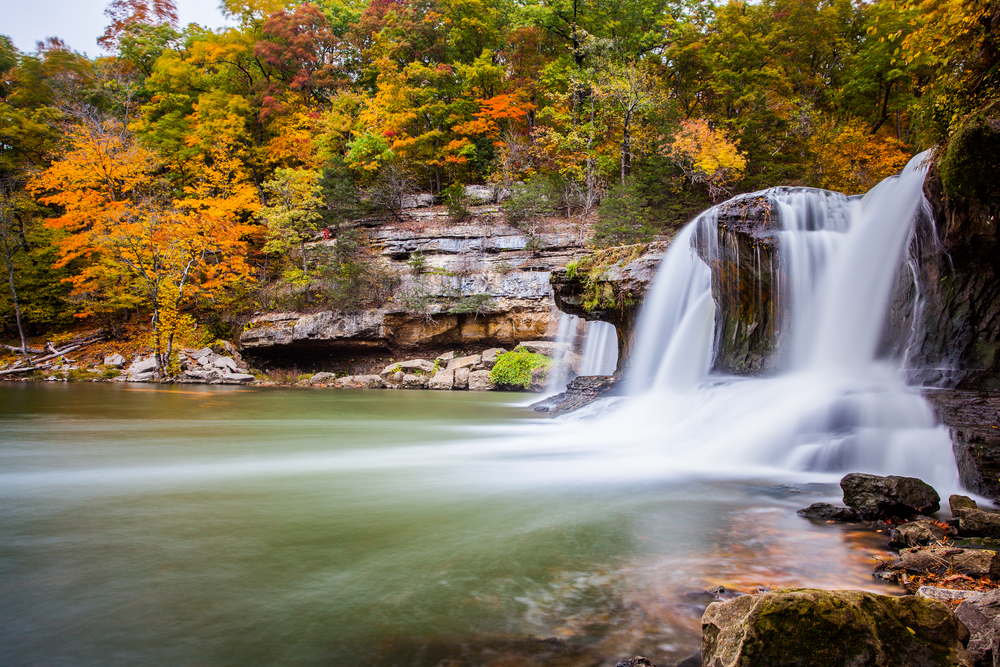 Cataract Falls viewed from the side with fall foilage seen on the clipptop in the background. One of the places to see fall in indiana.  