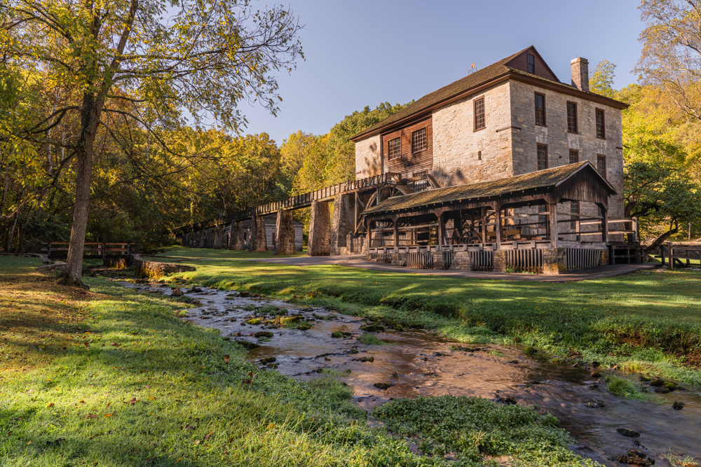 Old Mill at Spring Mill State Park on a crisp October day with autumn foilage in the background. 