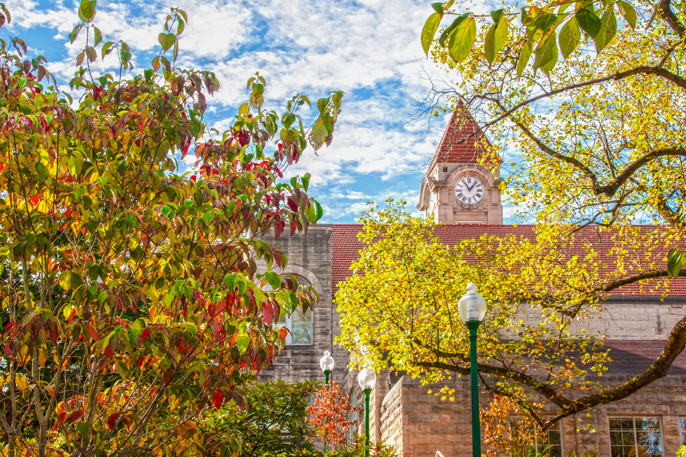 Clock tower and buildings on campus of Indiana University in Bloomington Indiana with fall foliage