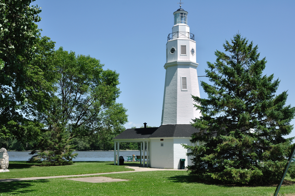 White Brick Lighthouse Located in Neenah, Wisconsin. The lighhouse is by the lake and surrounded by trees. Its one of the lighhouses is Wisconsin that you must visit. 