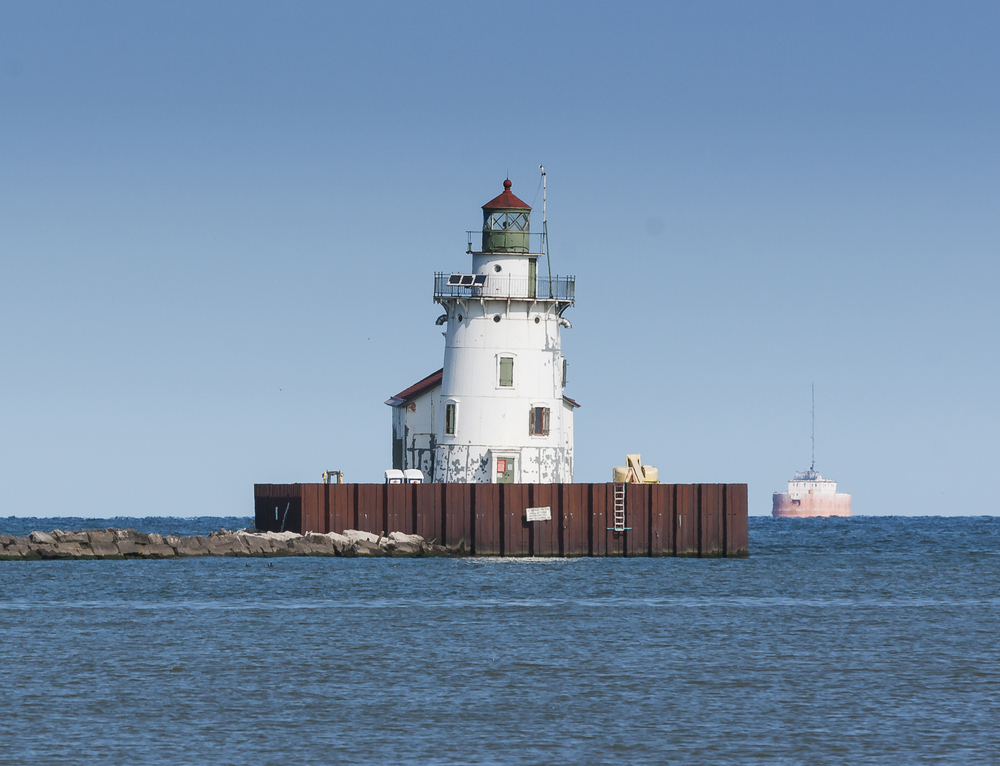 The Cleveland Harbor West Pierhead Lighthouse marks the western end of the entrance to the harbor at Cleveland, Ohio on Lake Erie. Its a white round building with a building attached to it. 