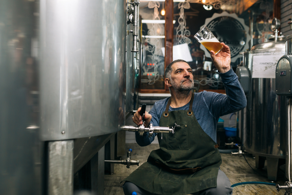 A brewer checking a beer from a distillery. 