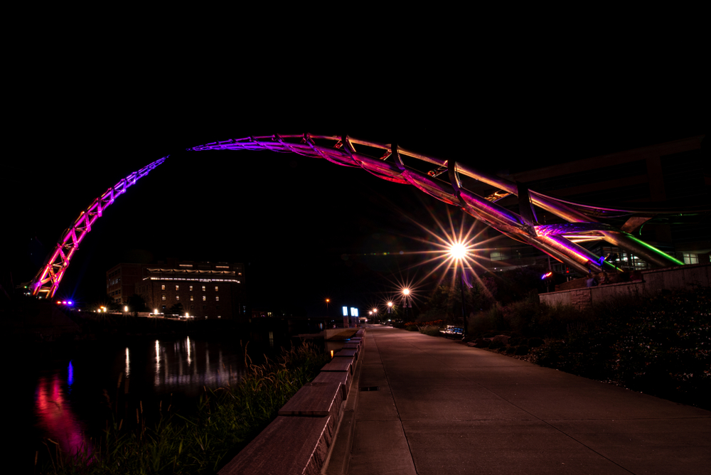 Nighttime shot of the Arc of Dreams lit up purple and pink.