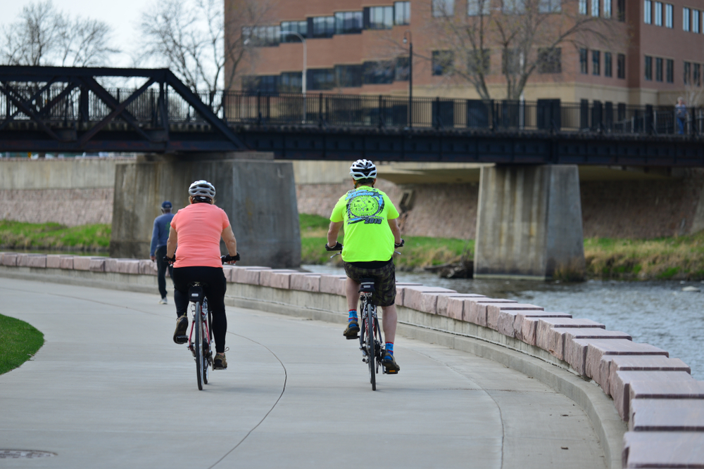 Bicyclers on the Sioux Fall Bike Trail next to the river.