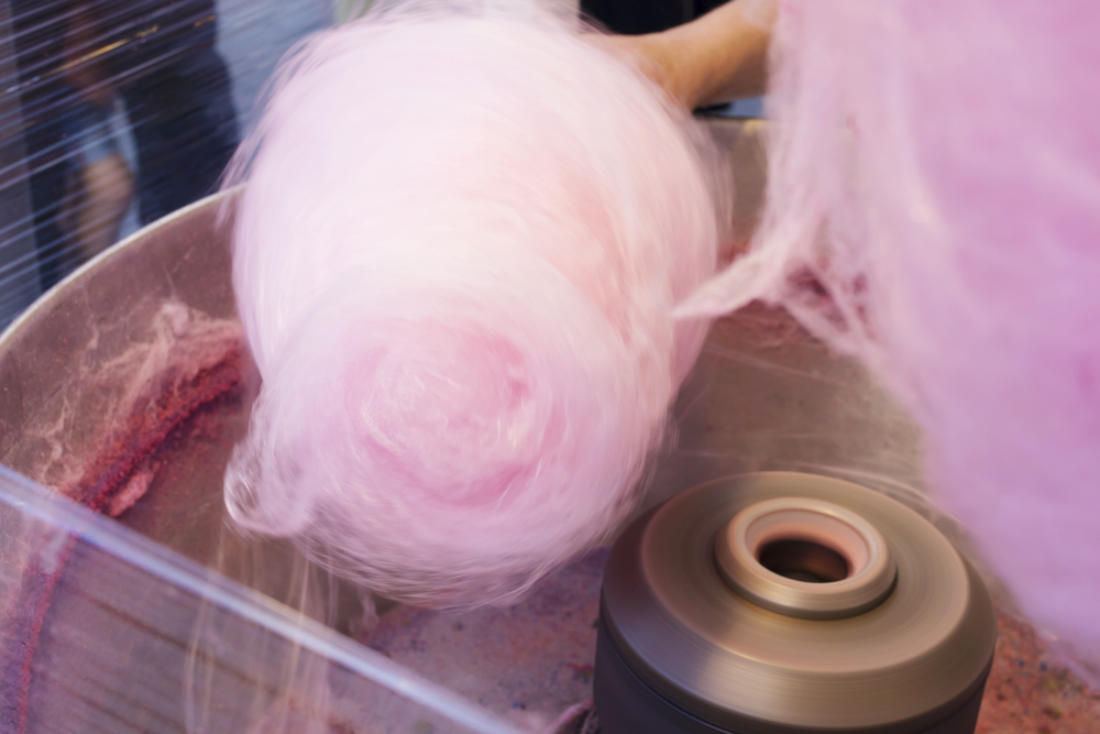 Pink cotton candy spinning in a machine.