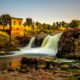 Shot of the waterfalls in front of the old mill in Falls Park, one of the best things to do in Sioux Falls, SD.