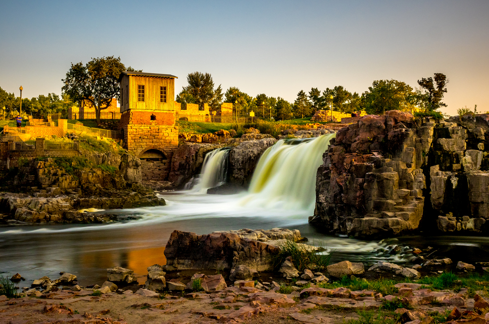 Shot of the waterfalls in front of the old mill in Falls Park, one of the best things to do in Sioux Falls, SD.