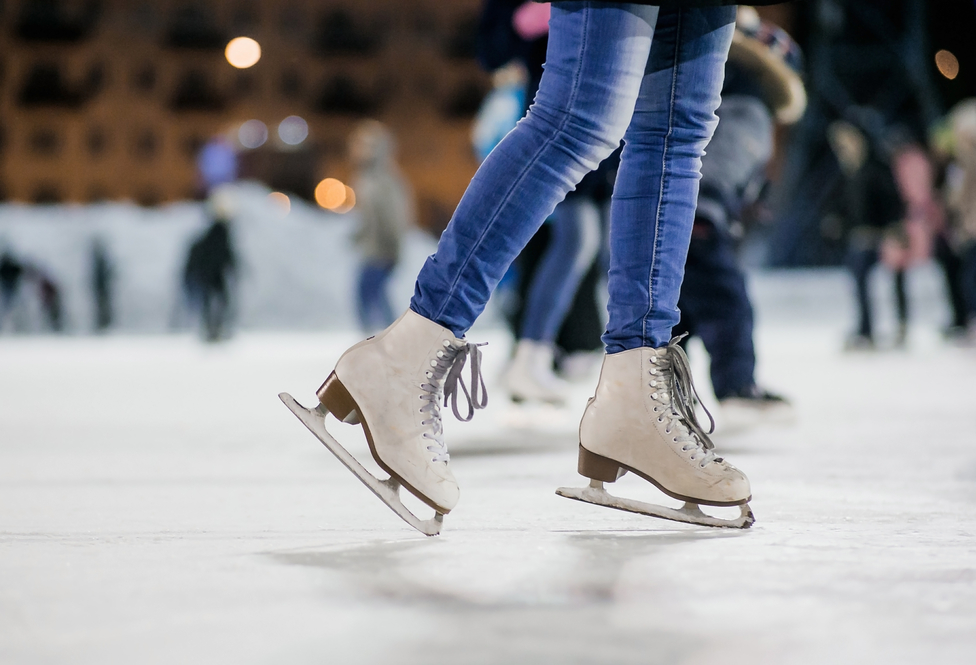 Close up of ice skates gliding on an ice rink during date night in Chicago.