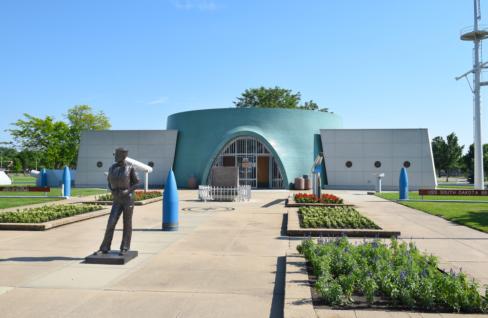 Entrance to the USS South Dakota Battleship Memorial with a statue of a sailor.