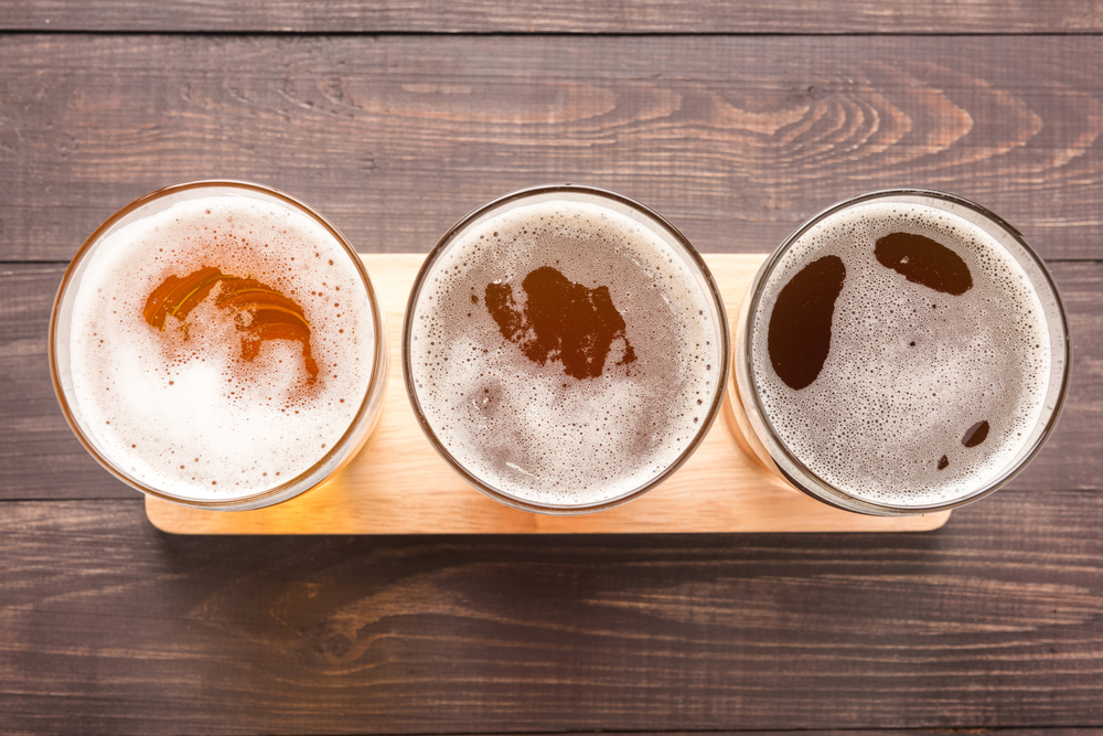 Looking straight down at three beers of varying colors.