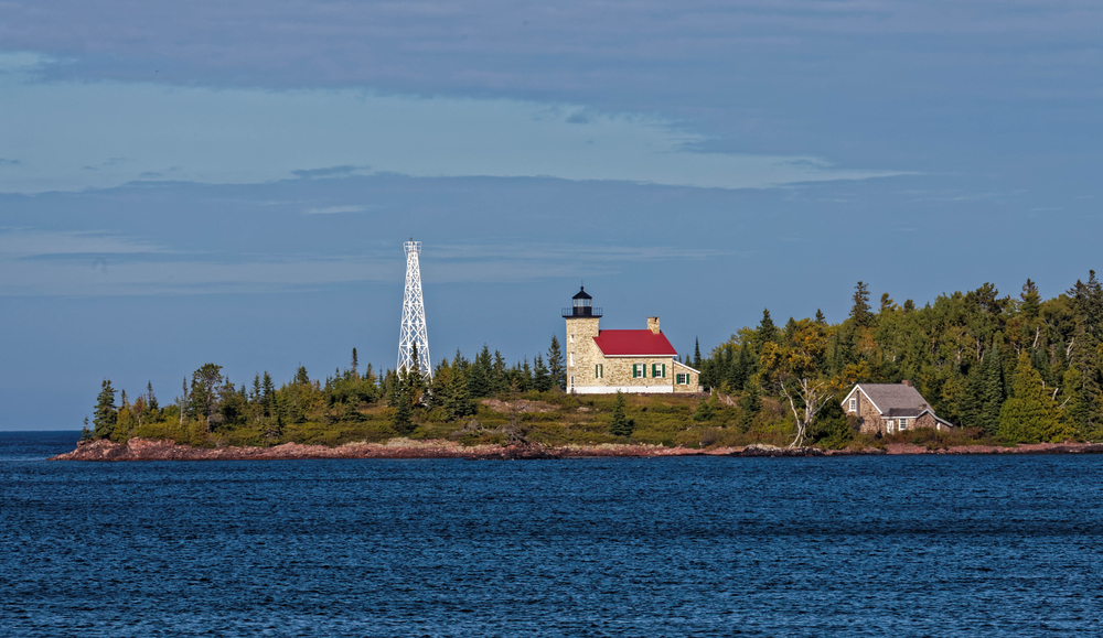 The Copper Harbor Lighthouse on an outcrop looking over the sea 