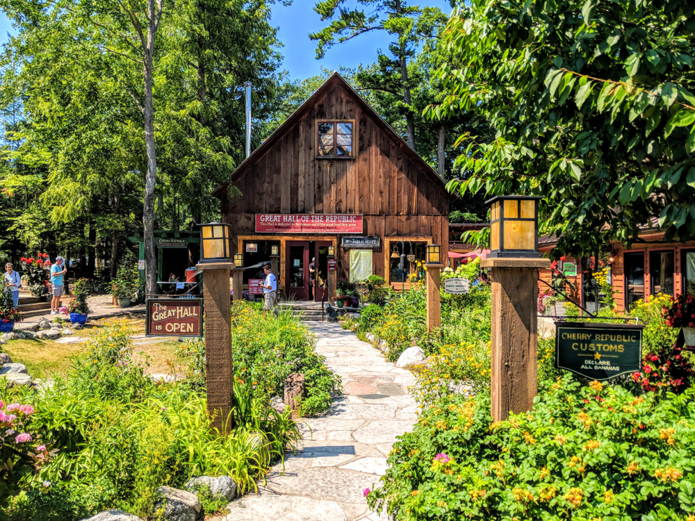 A brown vintage cabin in Glen Arbor it is surrounded by trees. This is oen of the beach towns in Michigan.  