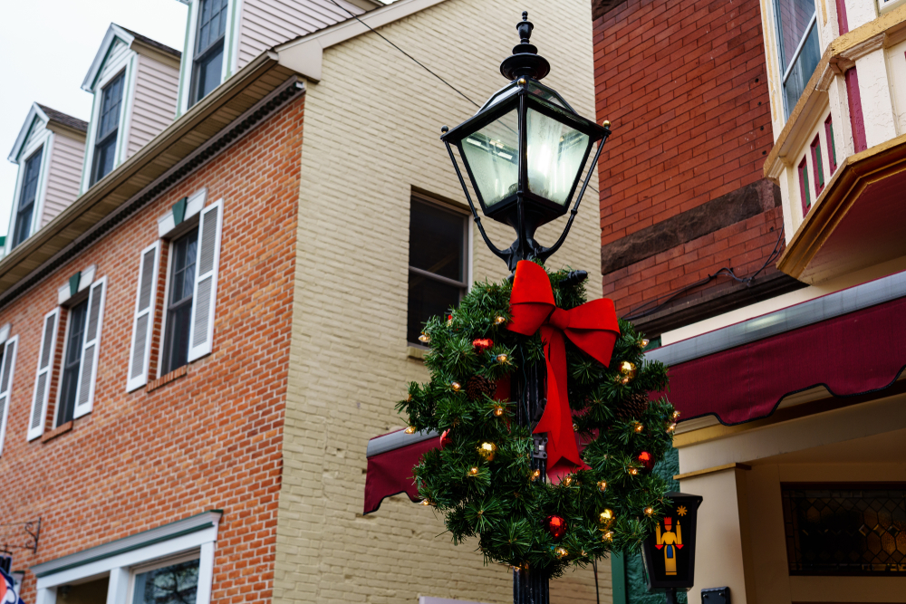 A light post with a wreath on a street with historic buildings during Christmas in Branson.
