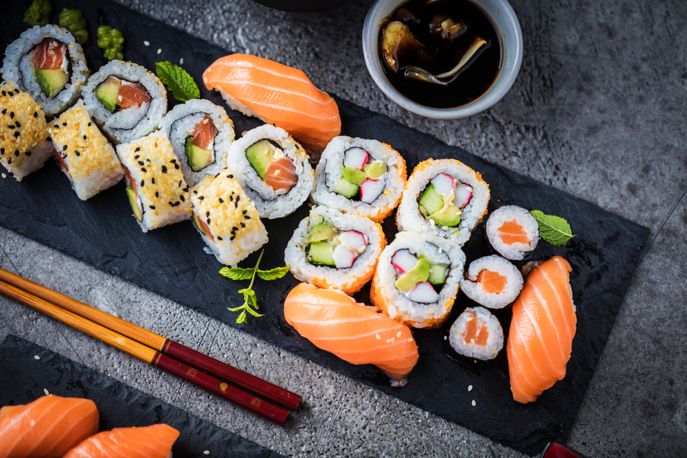 various Sushi on a plate with chop sticks in an article about restuarants in Bay City