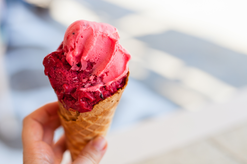 A person holding an ice cream cone with homemade strawberry sherbet. It's similar to what you can find at restaurants in Pierre. 