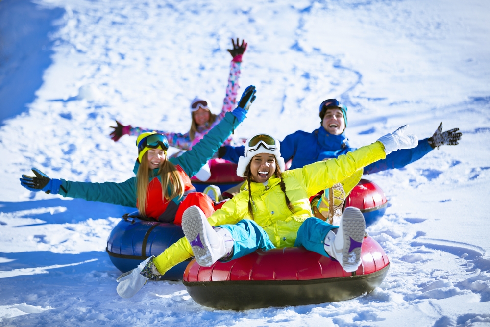 A group of people snow tubing down a hill in the winter