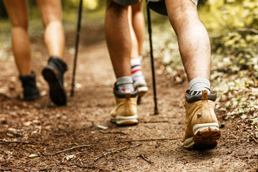 Three people hiking. The shot is of their feet walking. 