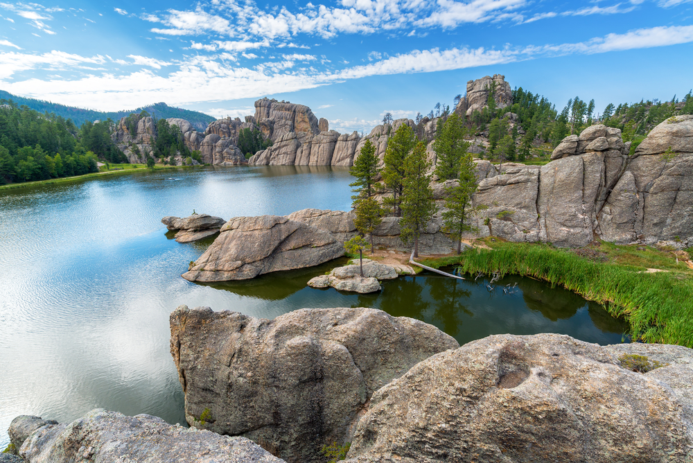 Beautiful Sylvan Lake in Custer State Park. The lake is surrounded by rocks and grass. 
