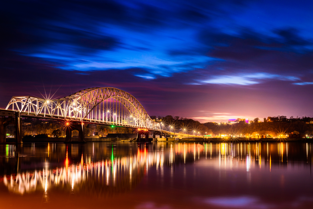 photo of a lit up bridge on top of a river at night things to do in dubuque