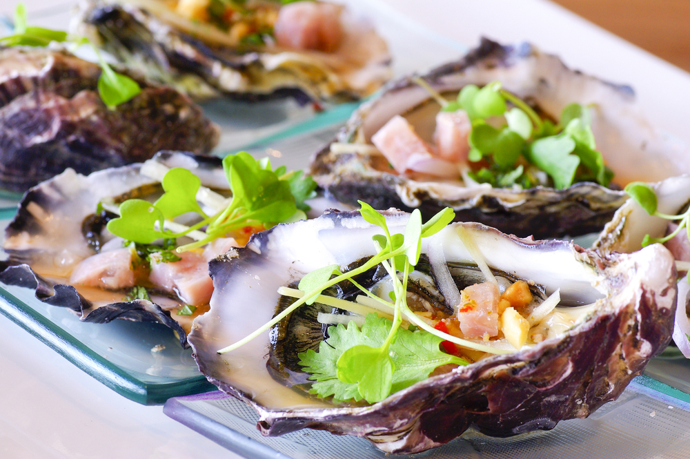 Oysters on aplate with dressing over them. 