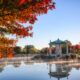 Look out at a gazebo in a lake during the fall in Missouri. You can see trees with fall foliage that is yellow, red, and orange.