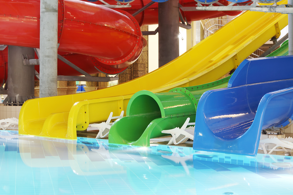 The exit of three different waterslides that are yellow, green, and blue at Wisconsin Dells waterparks. 