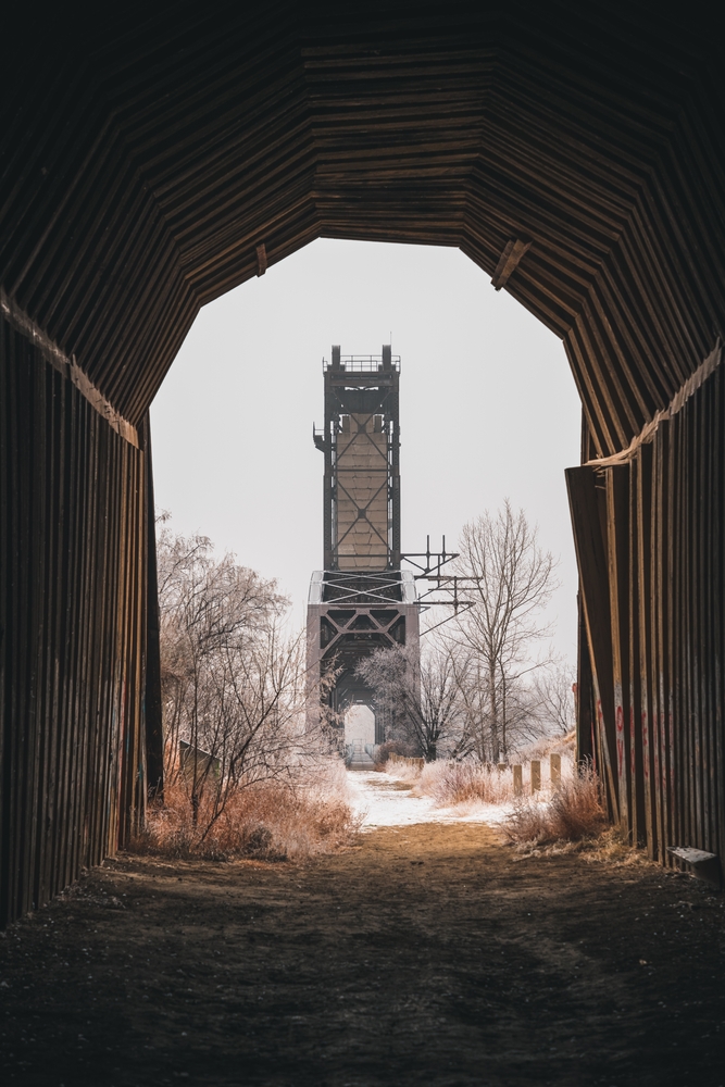 A vertical shot of Fairview Lift Bridge in North Dakota. It is taken from a tunnel and shows the snowy bridge which is disused.  