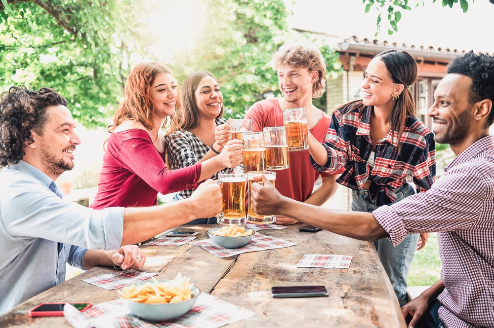 A group of adults doing cheers with their pints of beer at an outdoor festival. It's something you can do during fall in Chicago.