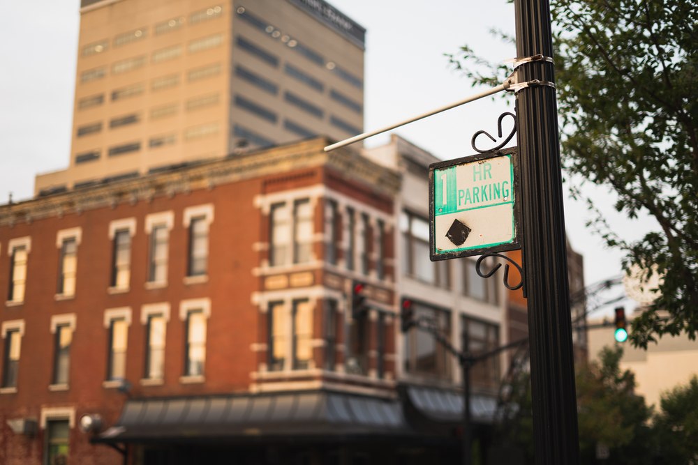 Downtown Evansville with a brown building in the background and a parking sign in the foreground. The article is about resturants in Evansville