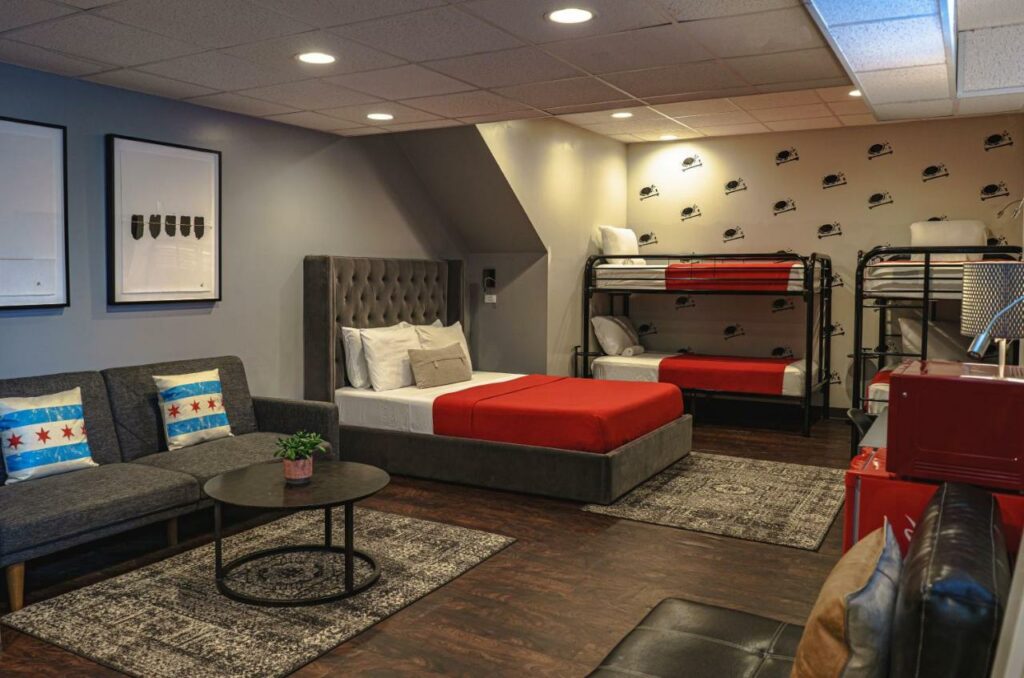 A dorm room at the Chicago Getaway Hostel with multiple beds and a couch.