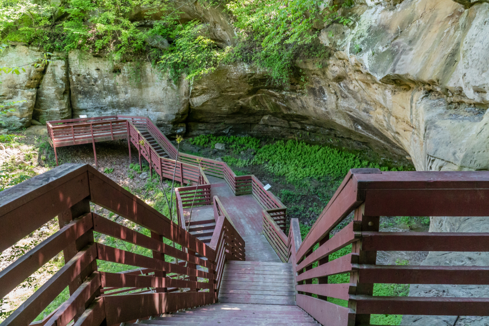 Red staircase leading to a cave surrounded by greenery hiking in Nebraska