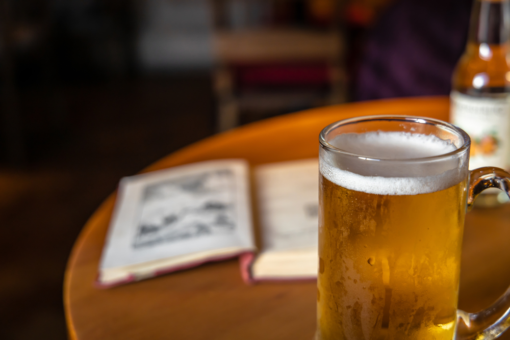 Mug of cold craft beer and opened book in the pub in an article about breweries in Cleveland