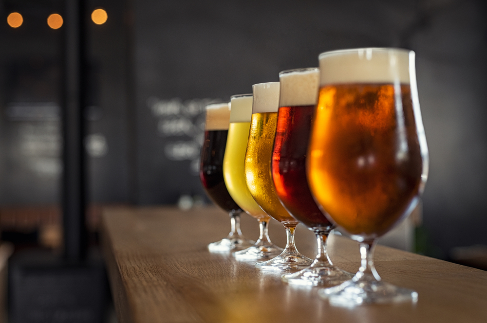 Five beers lined up on a bar 