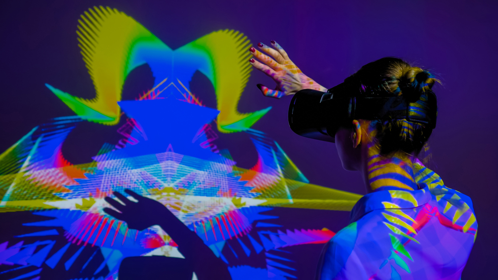 A person with a VR headset on interacting with an immersive modern art exhibit in a museum