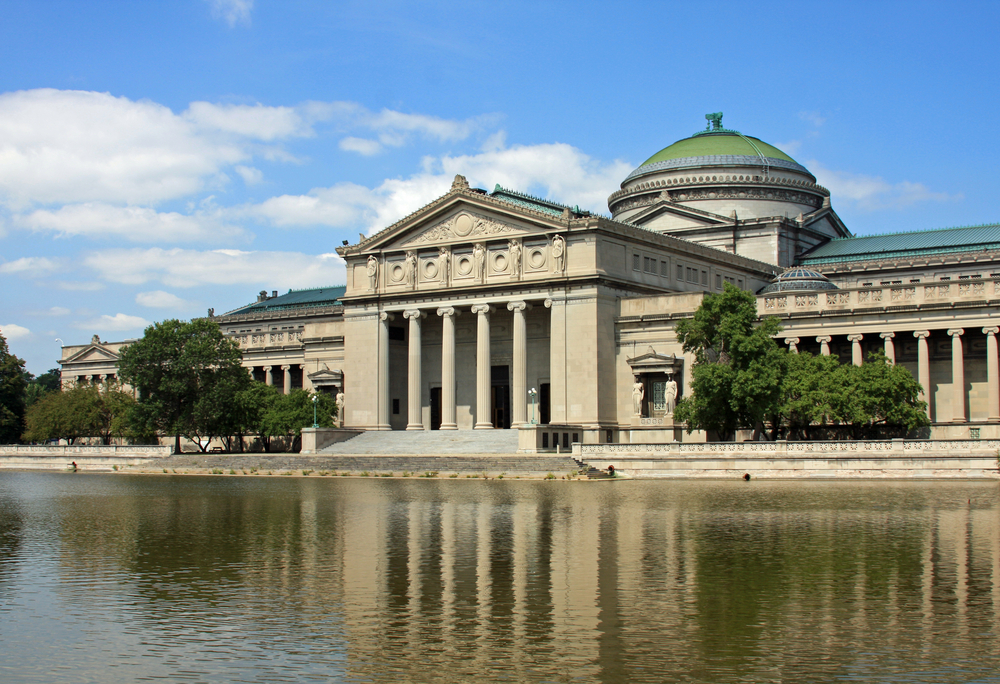 The front exterior of the Chicago museum of science and industry on a sunny day. 