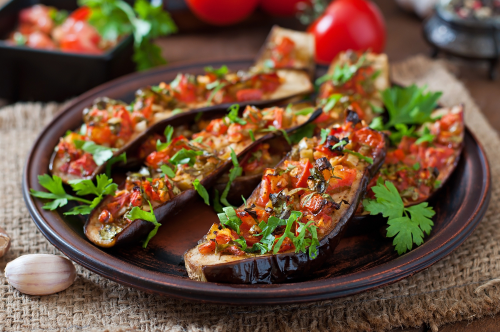 Baked eggplant with tomatoes, garlic and paprika on a plate in one of the vegan restaurants in Akron