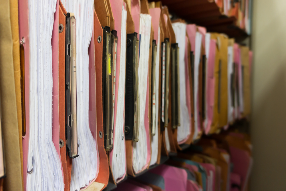 Traditional filing cabinets filled with files of several colors.Abstract background image of colorful hanging file folders in drawer.