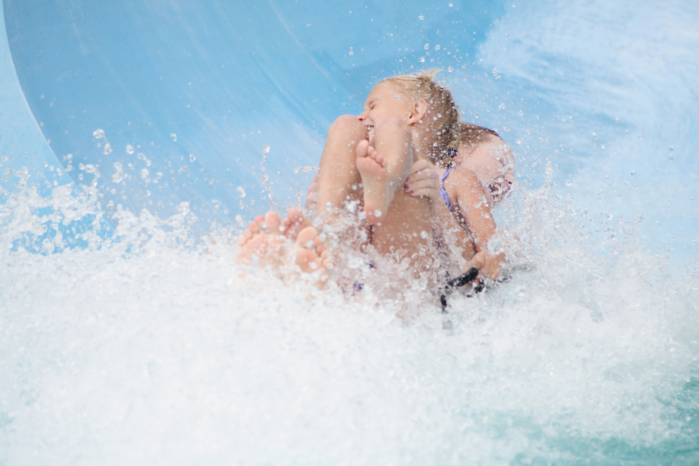 two girls having fun coming down a waterslide