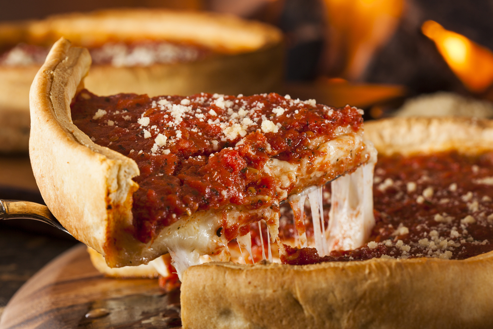 Thick slice of pizza being lifted from a Chicago deep dish pizza.