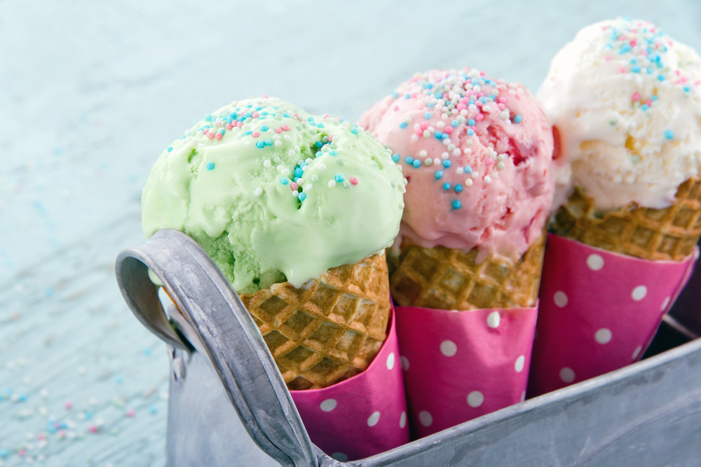 Three ice cream cones with sprinkles.