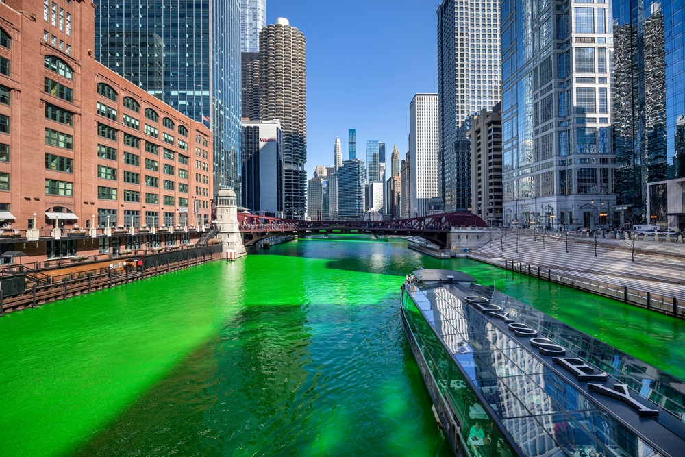 Glass boat cruises through the dyed green river in Chicago.