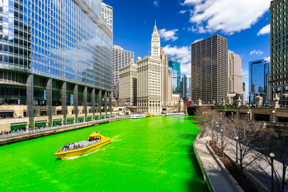 A speedboat going down the Chicago River when it is dyed green for St. Patrick's Day.