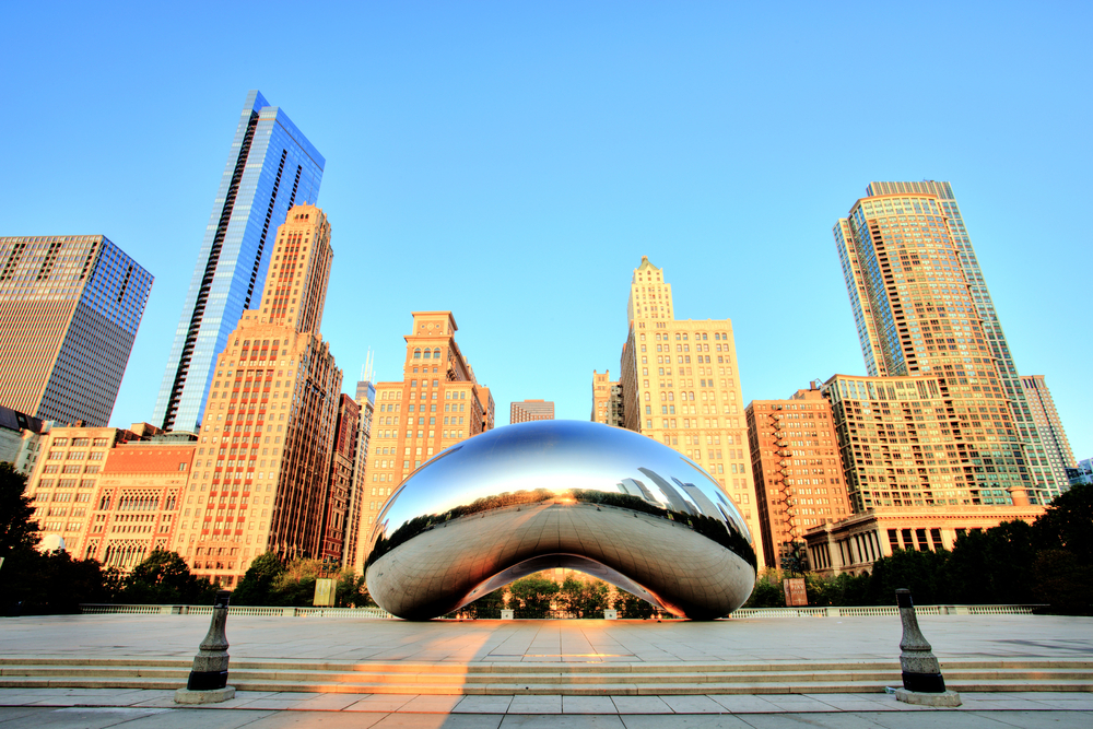 Morning golden hour at the Bean sculpture with the skyline in the background.