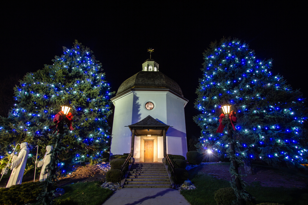 The Silent Night Memorial Chapel in Frankenmuth with two Christmas trees at either side with blue lights 