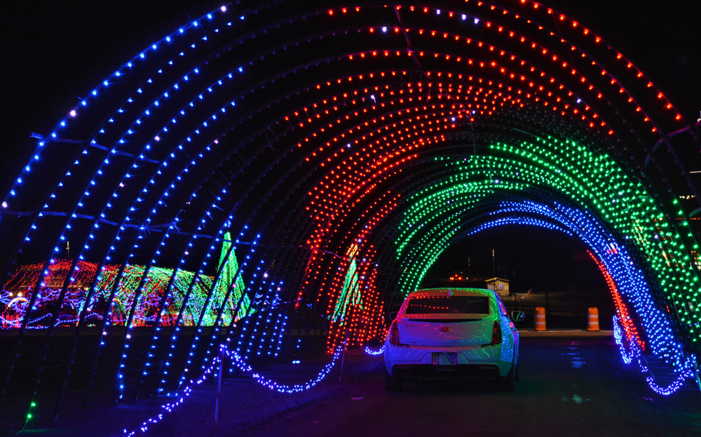 A Light tunnel with a white car driving through it 
