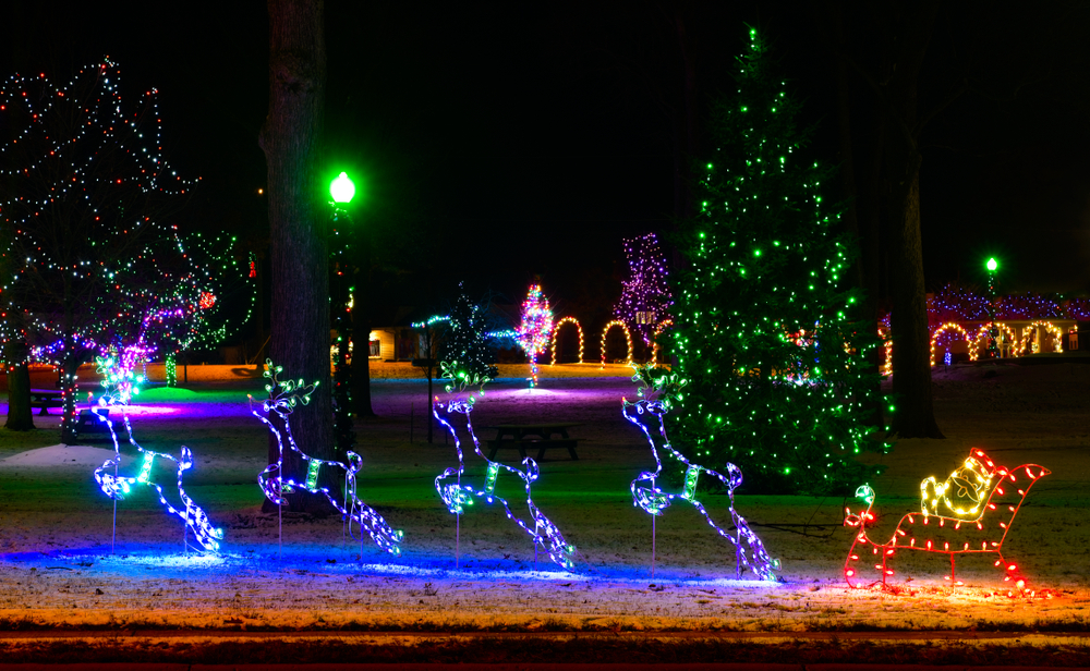 Christmas display featuring a lighted Santa in sleigh and four purple reindeer. 