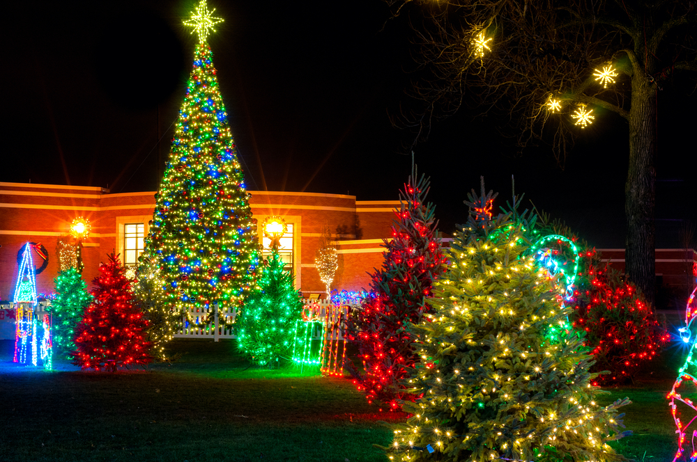 The colorful outdoor Christmas display in Strongsville, Ohio with Christmas trees and a building in the background. 