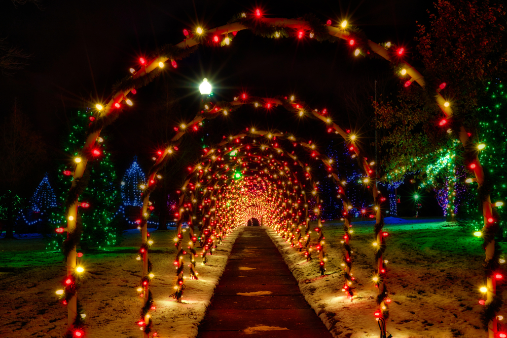 A festive tunnel of lighted arches in a village square Christmas setting