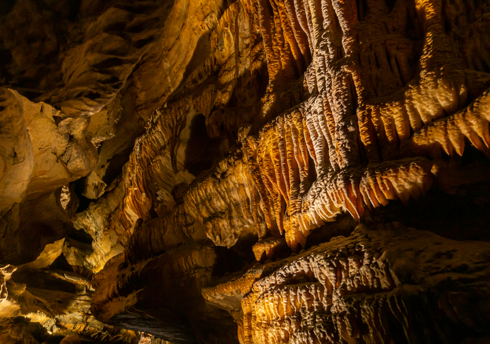 Orange, brown, and cream colored rock formations inside a cavern in Ohio