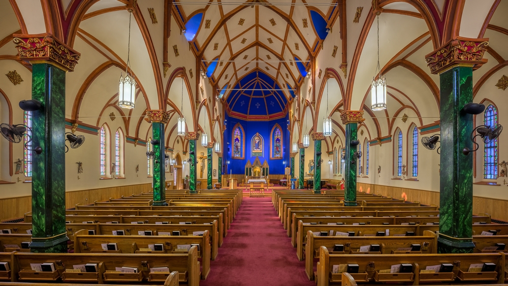 Looking at the elaborately decorated Church with a bright blue wall, cathedral ceilings, green stone pillars, and stained glass windows, one of the best things to do in Sault Ste Marie